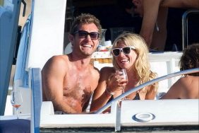 Jude Law, black swim trunks, sunglasses, Sienna Miller, black string bikini, sunglasses, wine glass